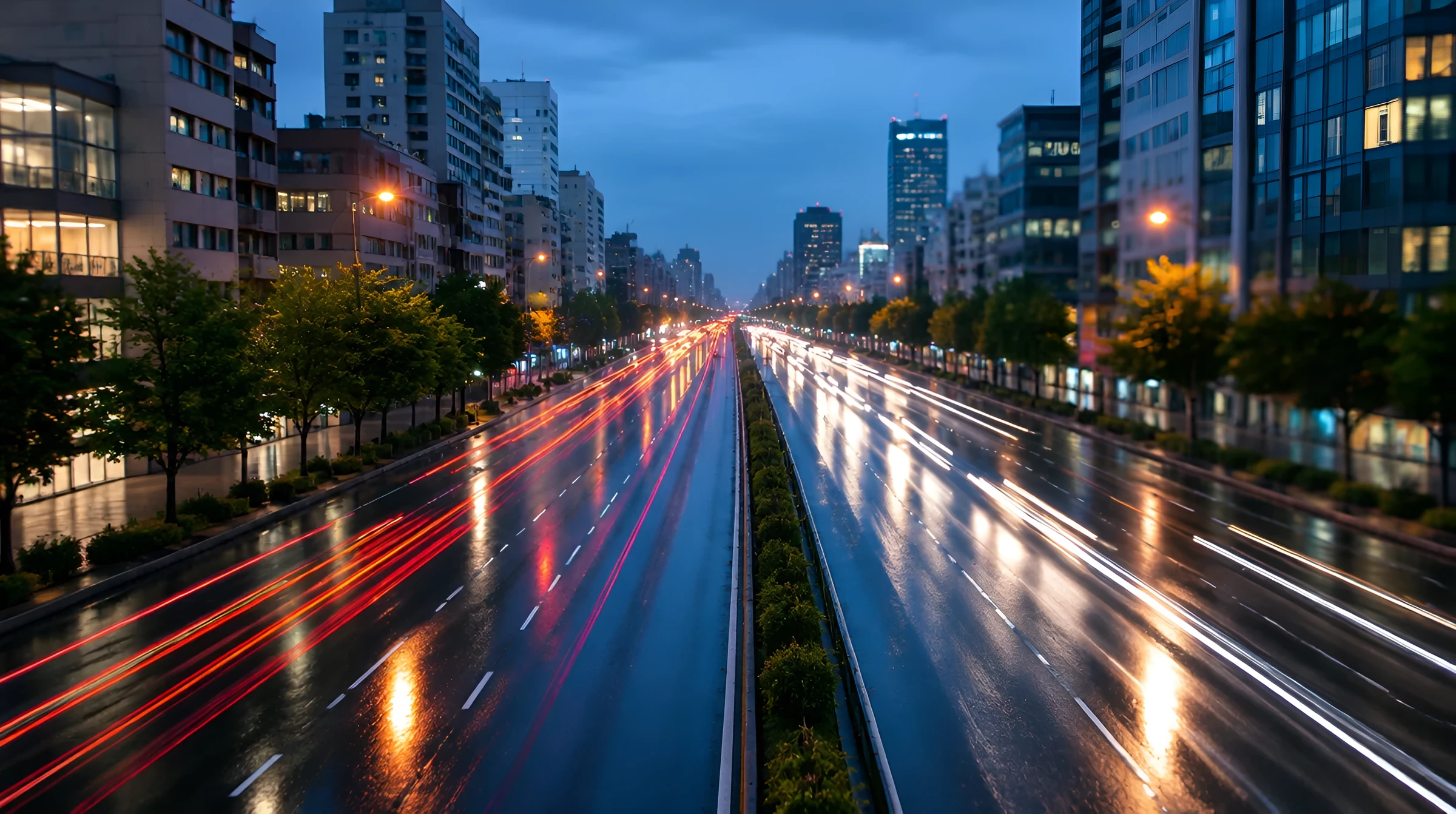 雨の夜の大通りを走る車のライト