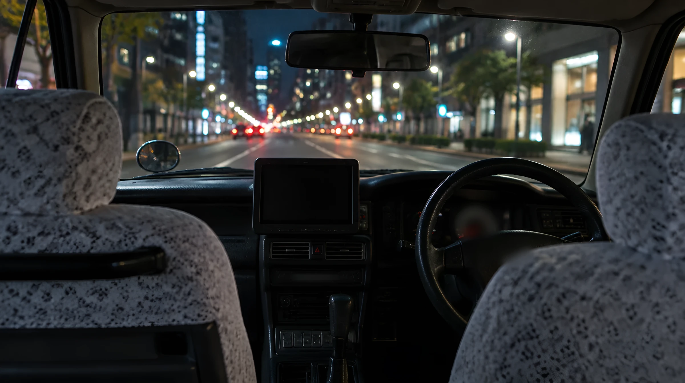 夜のタクシーの後部座席から見た運転席のまわり
